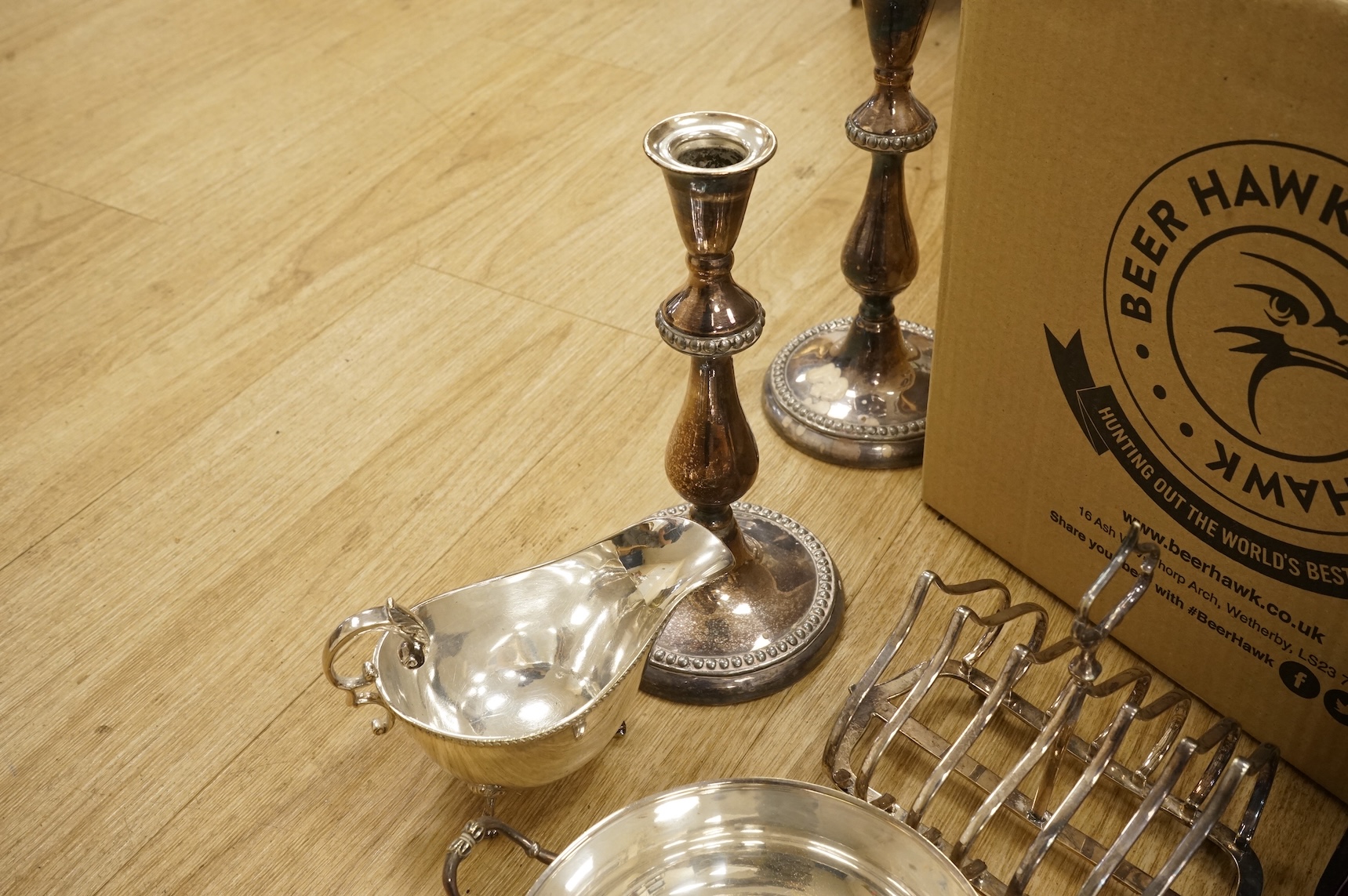 A quantity of assorted plated wares, including flatware, a tea caddy, a chatelaine, a toast rack, a sauceboat, a butter dish and a pair of candlesticks, etc.